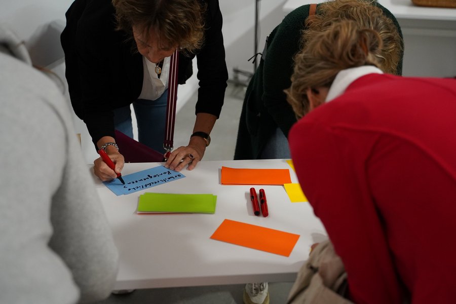 Workshop-Teilnehmende schreiben Stichworte auf bunte Zettel.